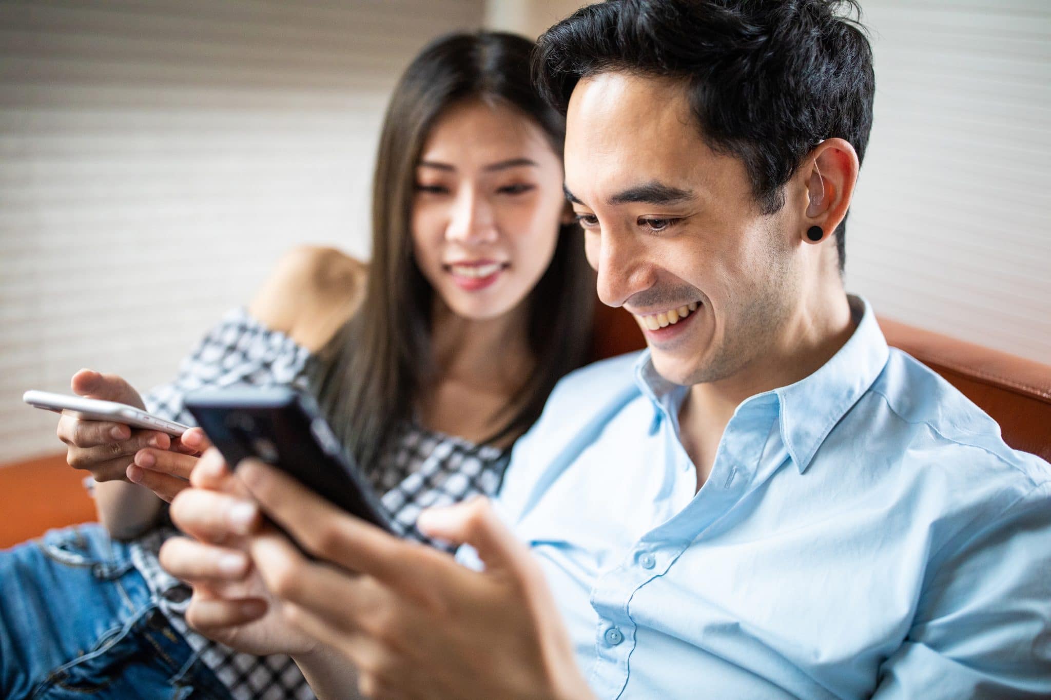 Man with hearing aids uses his phone.