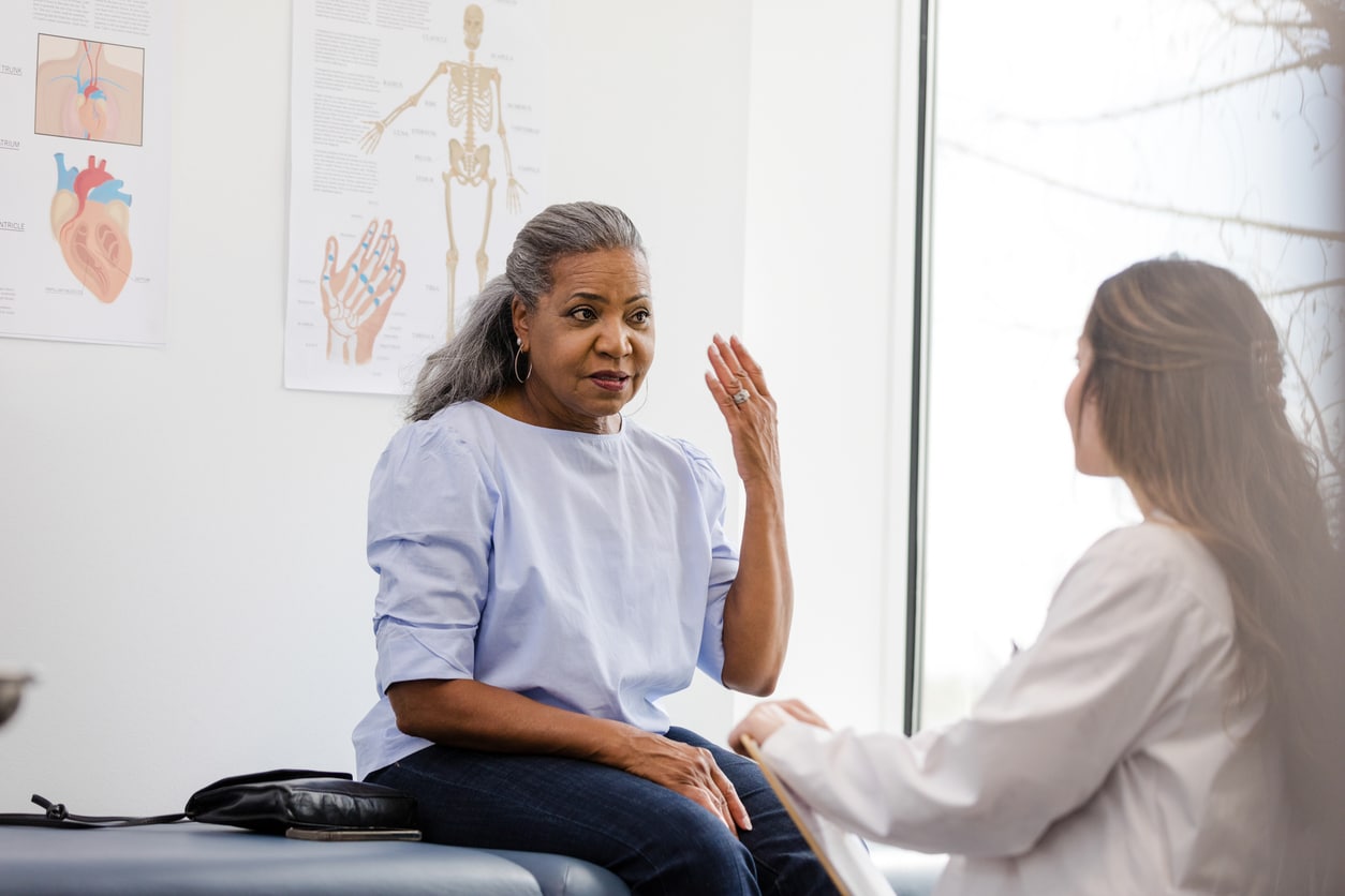 Woman explaining her hearing loss to her audiology