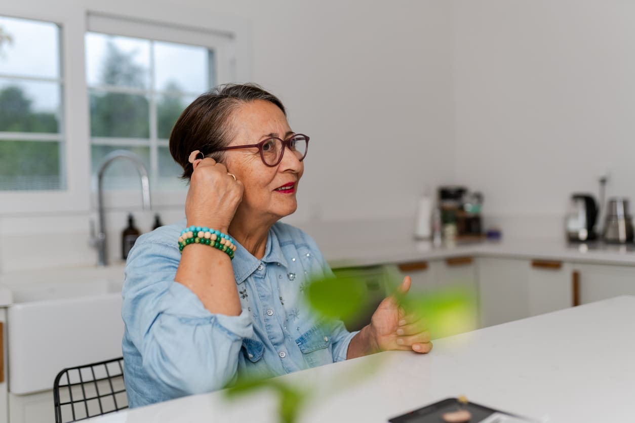 Woman adjusting her new hearing aid